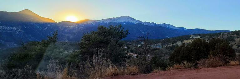 Image of sun setting behind the front range and pikes peak